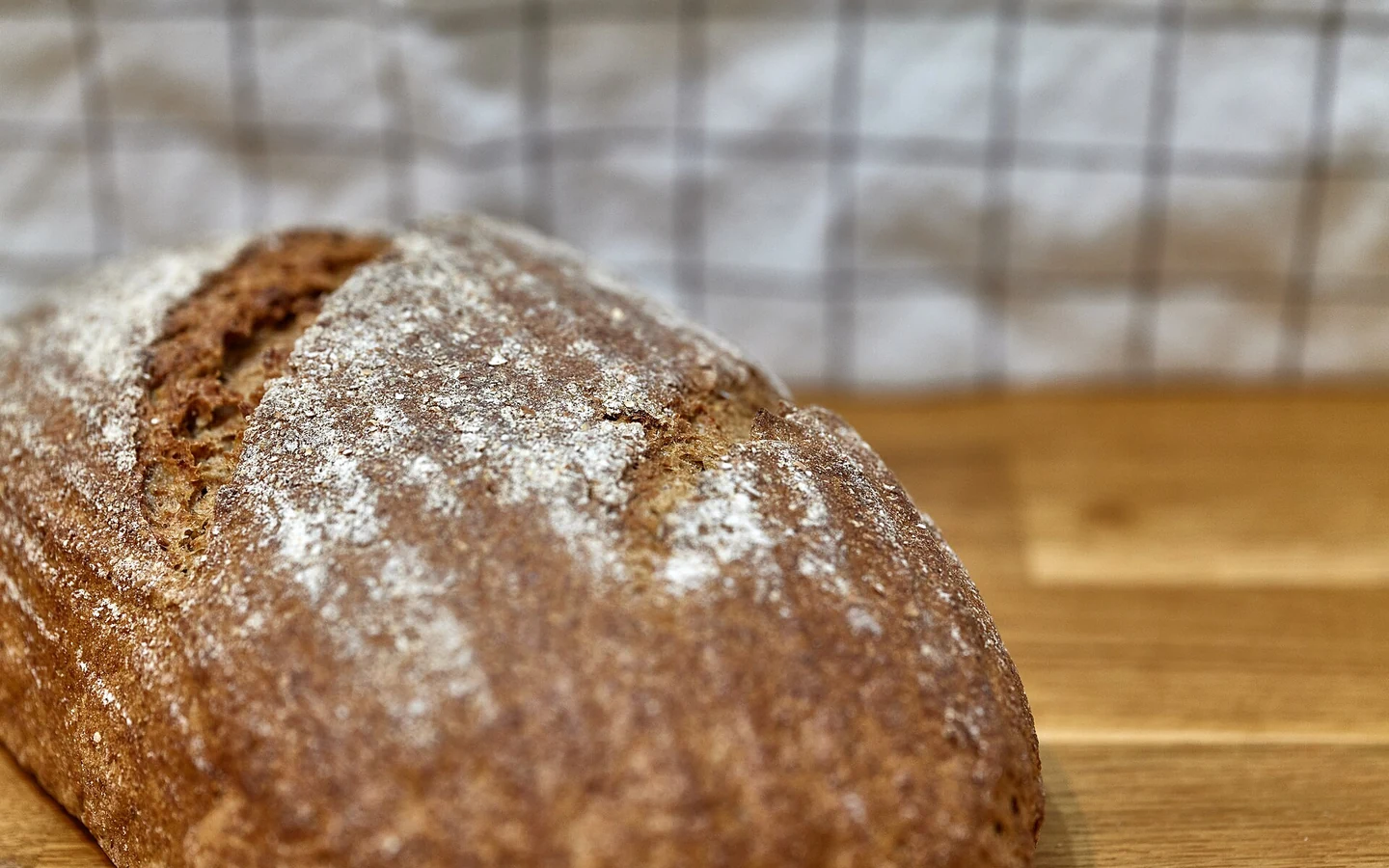 A German rye loaf with a dark crust is shown close up.