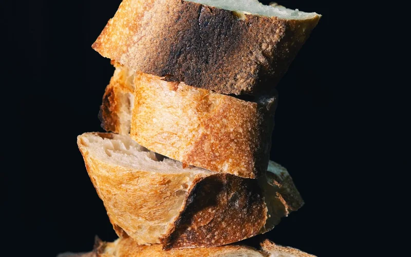 Sliced bread shows its crust and interior crumb.