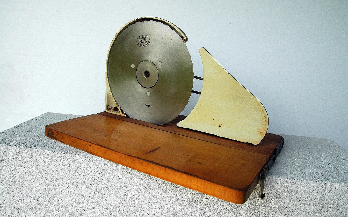 A historic manual bread-slicing machine is displayed in a bakery museum.